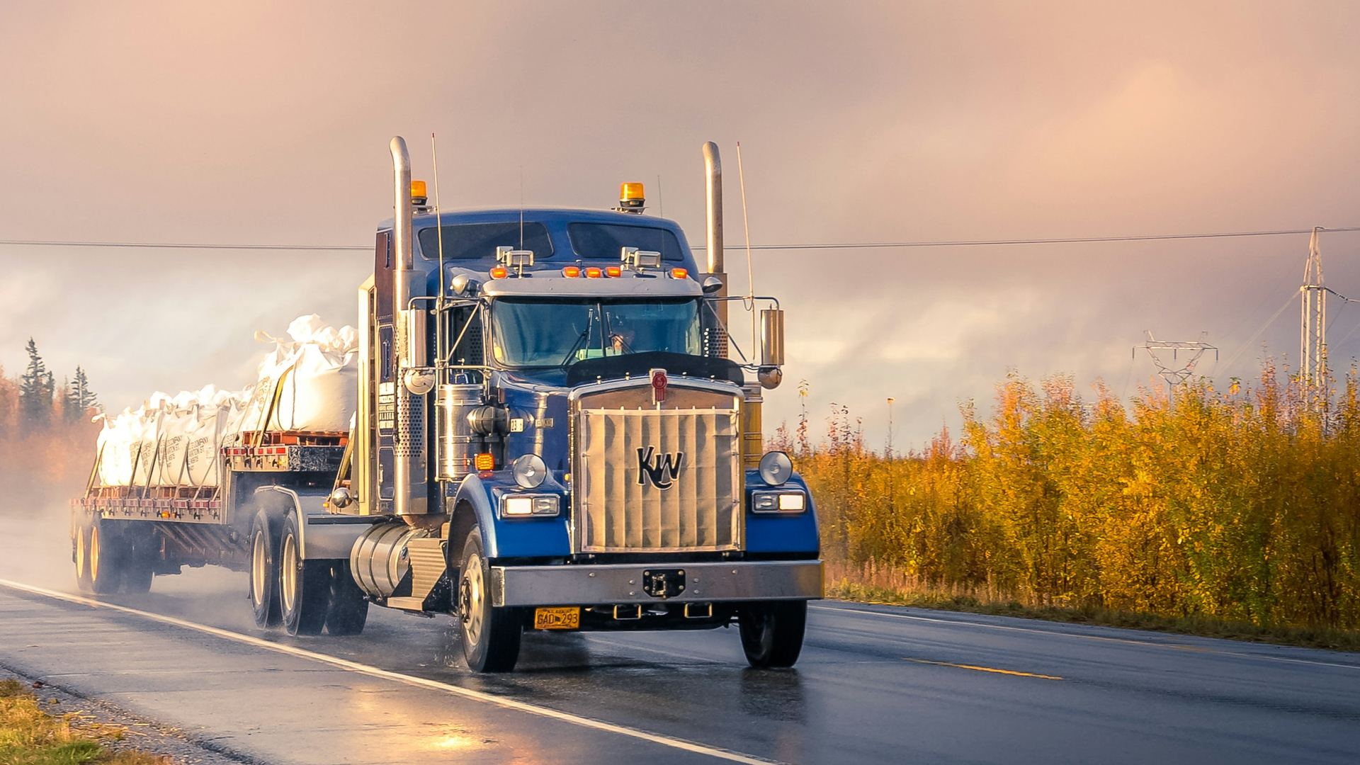 Cabezal con plataforma cargada transportando mercadería por carretera