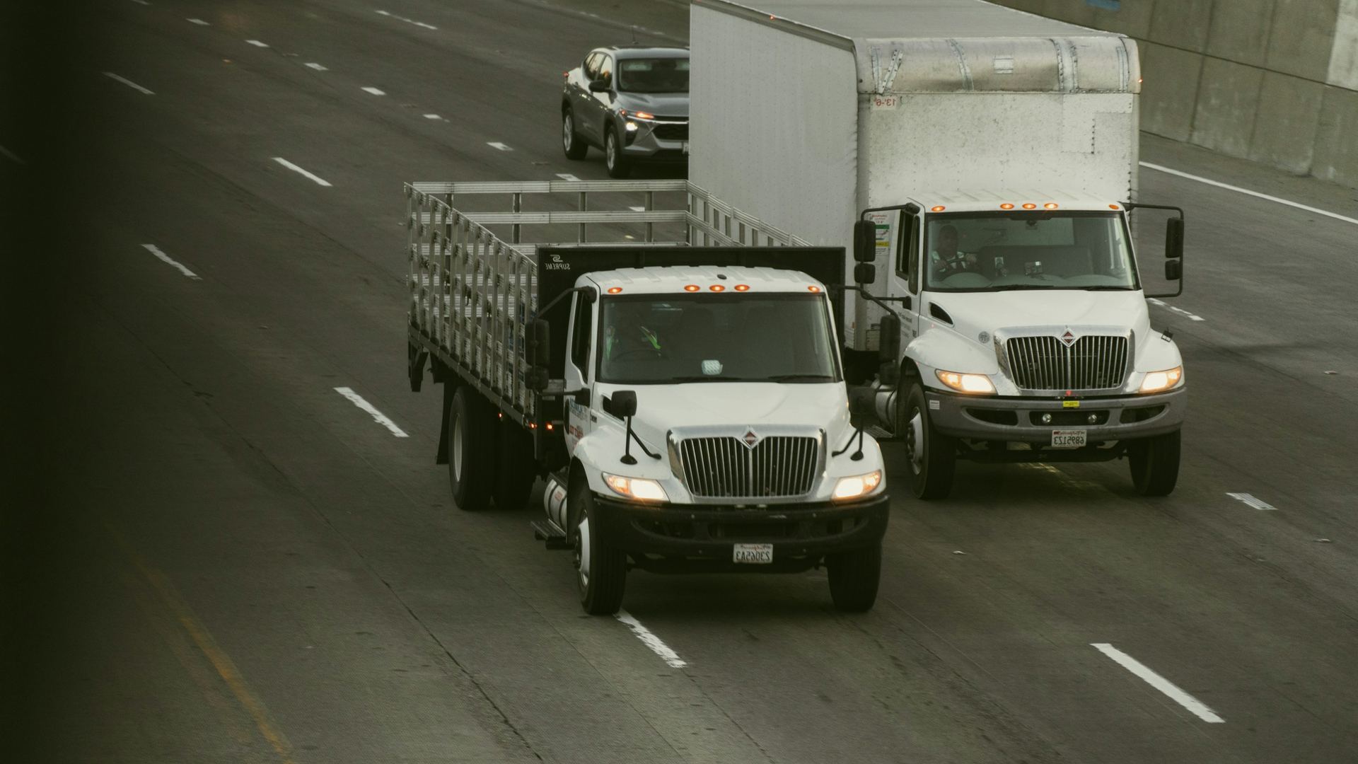 Camiones de carga de cinco toneladas con furgón circulando por autopista